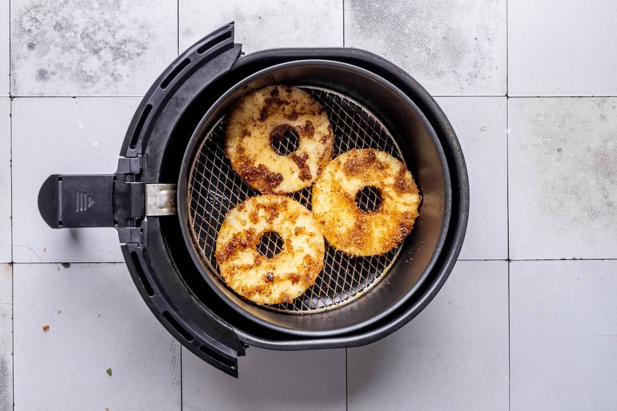 seasoned pineapple in the air fryer basket.
