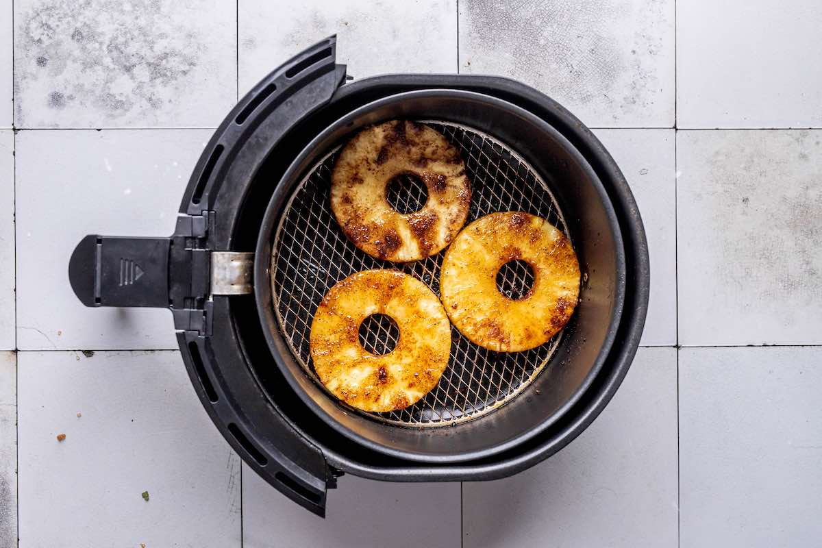 air fried pineapple in the air fryer basket.