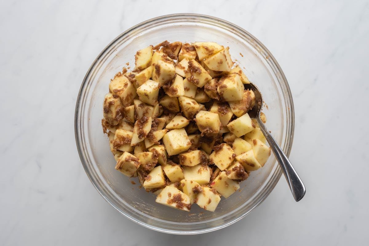 choppd apples and spices mixed in a bowl.