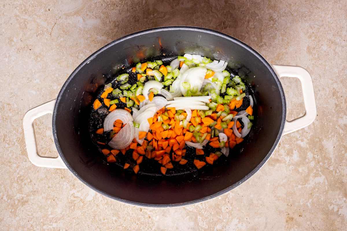 carrots, onion, and celery simmering in a pot.