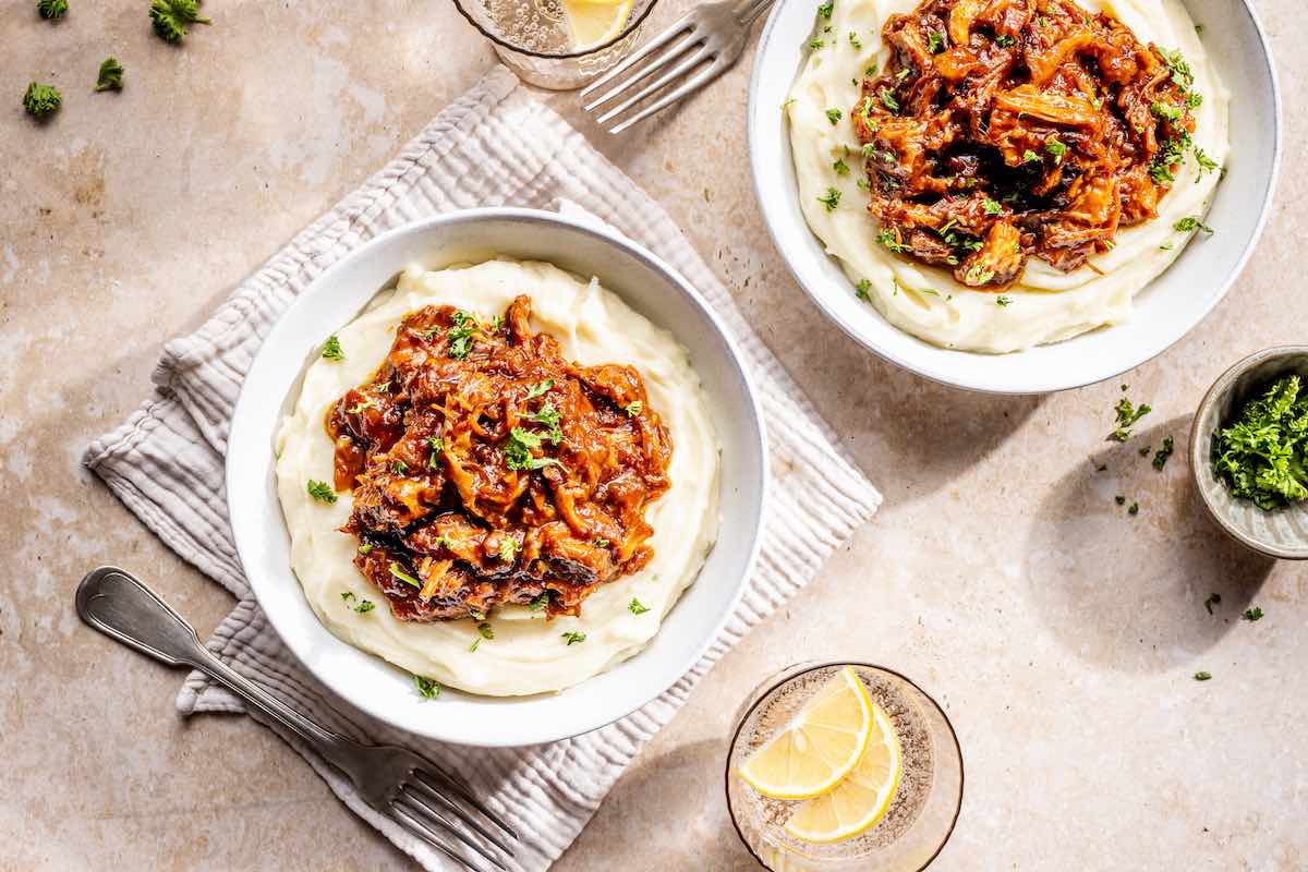 bowls of mashed potatoes with boneless beef short ribs on top.
