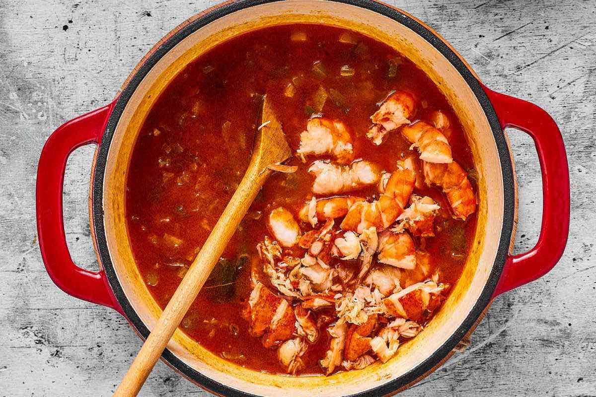 adding crawfish tails to broth and Cajun trio.
