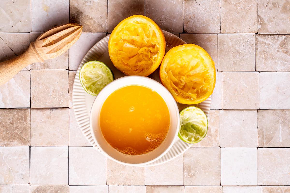 juiced orange and limes in a bowl.