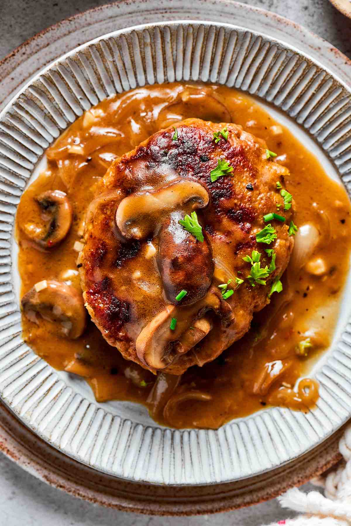 homemade salisbury steak on a bed of mashed potatoes.