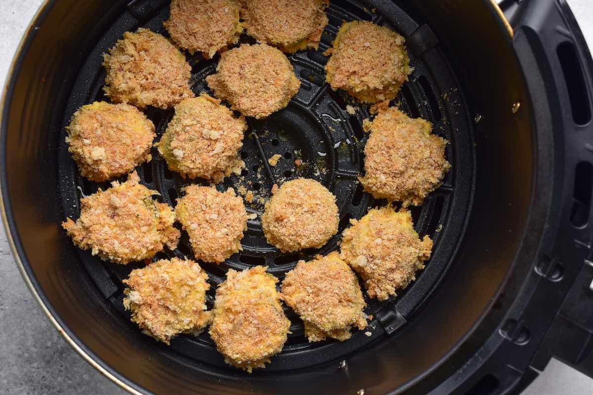breaded pickles in air fryer basket.