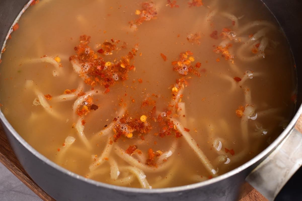 simmering broth with chili peppers.