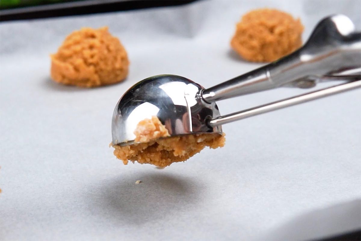 scooping balls of cookie dough on baking sheet.