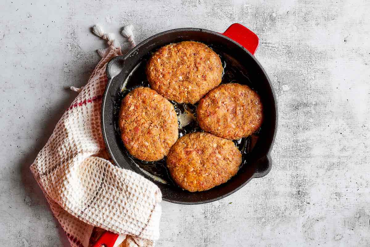 shaped patties simmering in a skillet.