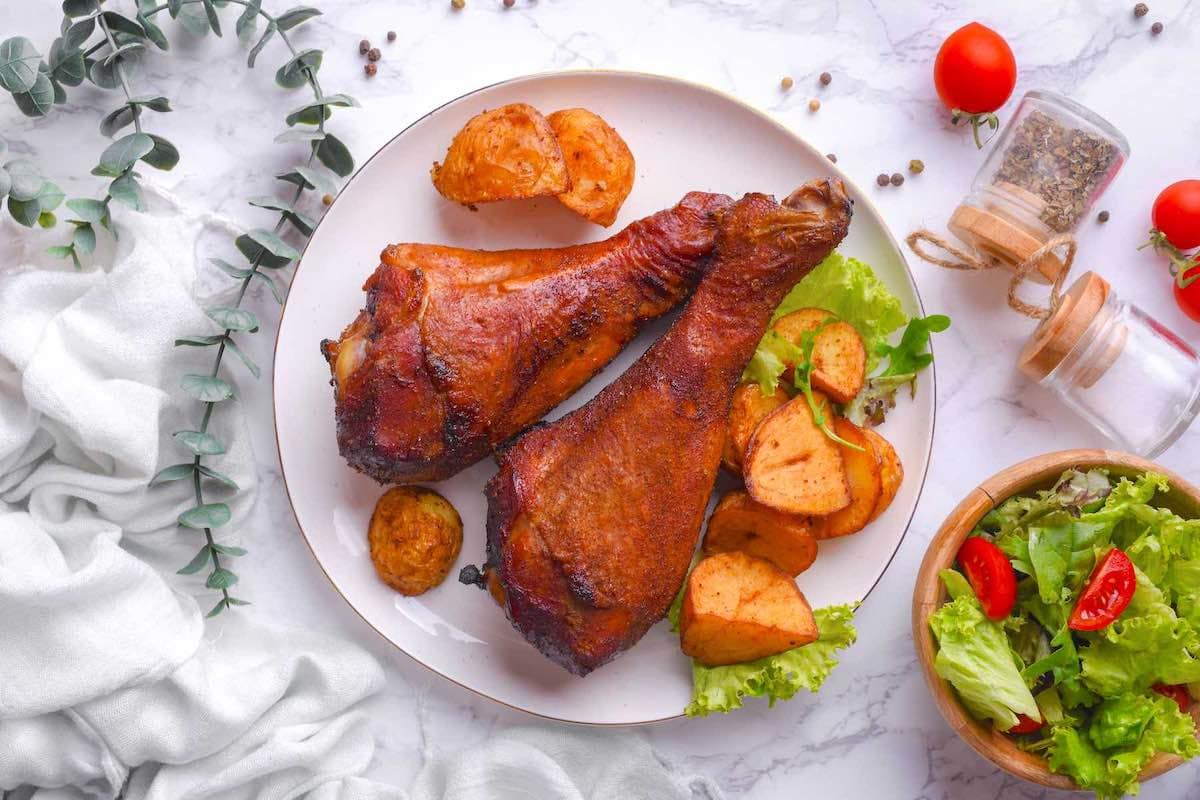smoked turkey legs served with potatoes.
