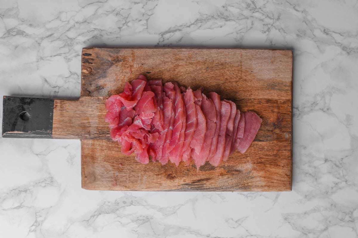 sliced raw tuna on a chopping board.