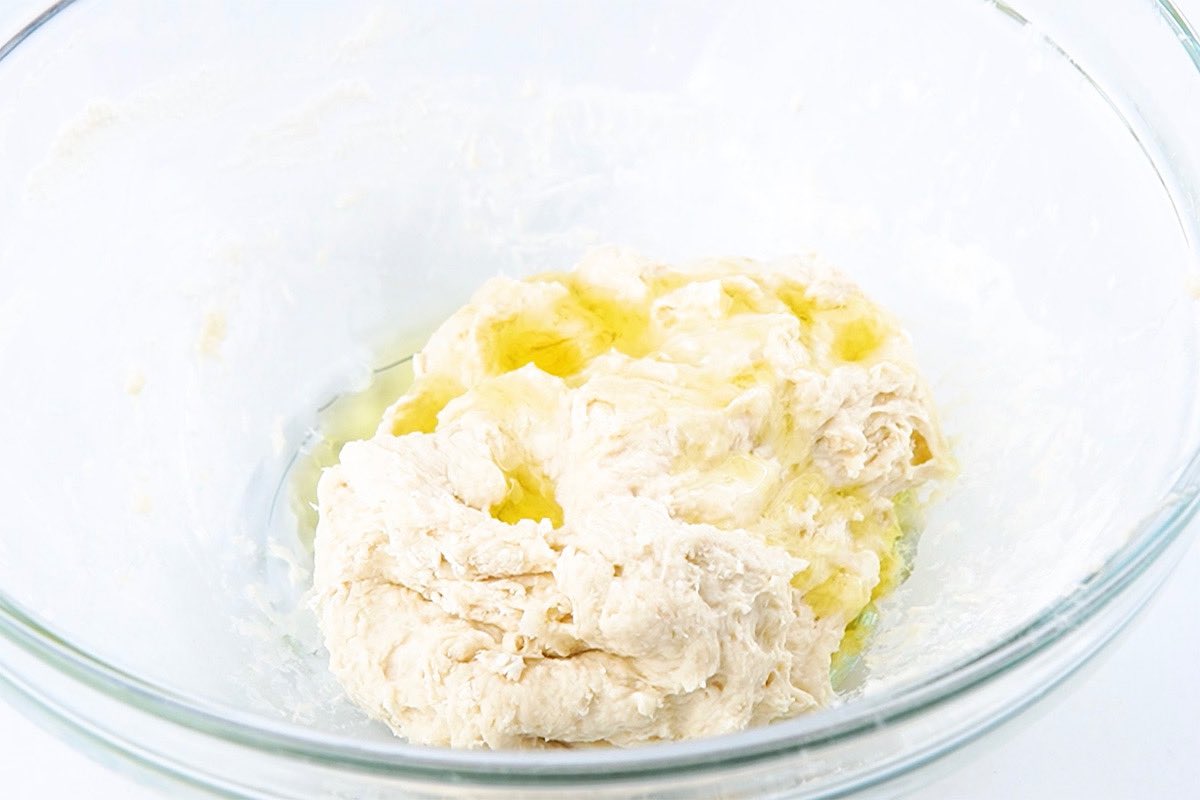yeast, flour, water, and oil in bowl.