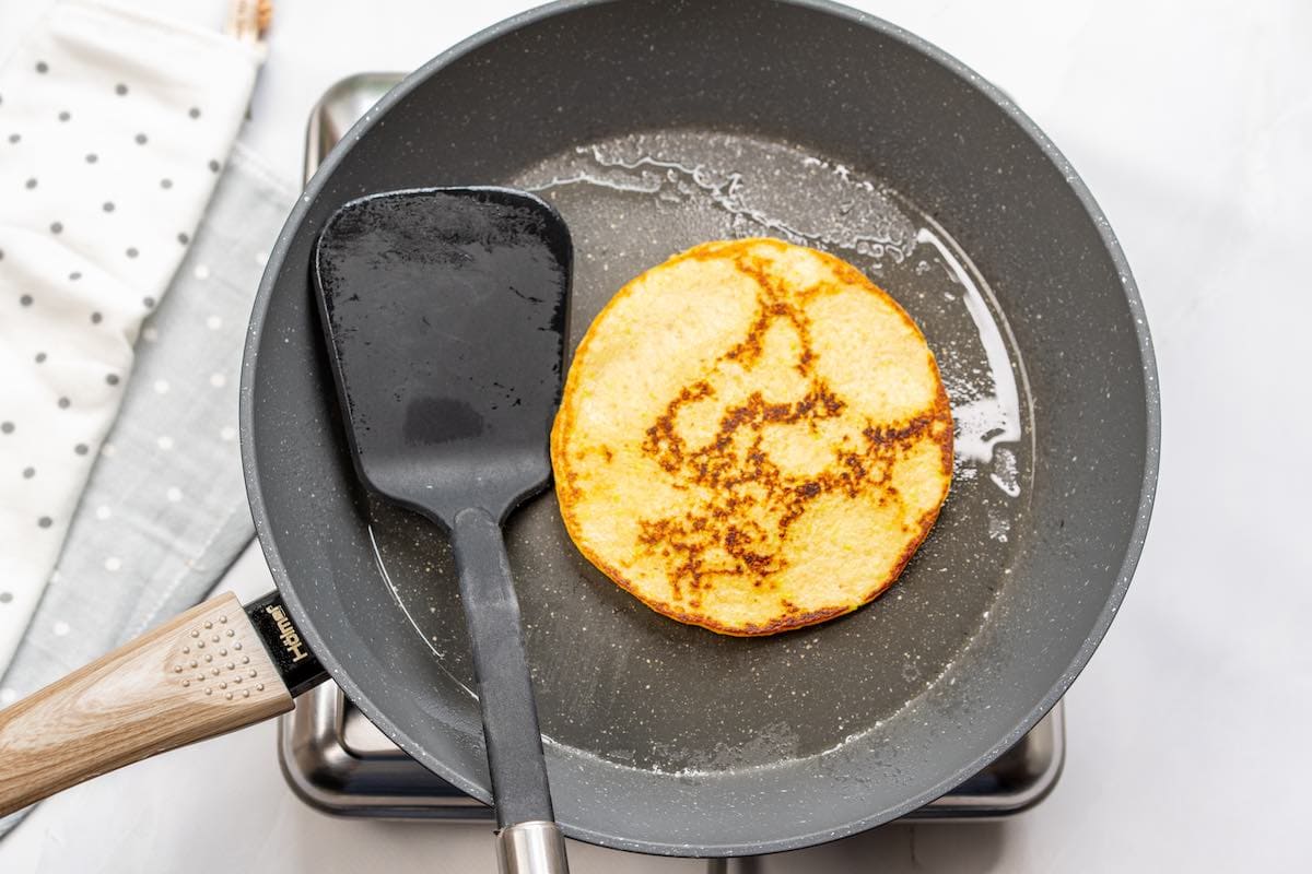 cooked zucchini pancake in a skillet.