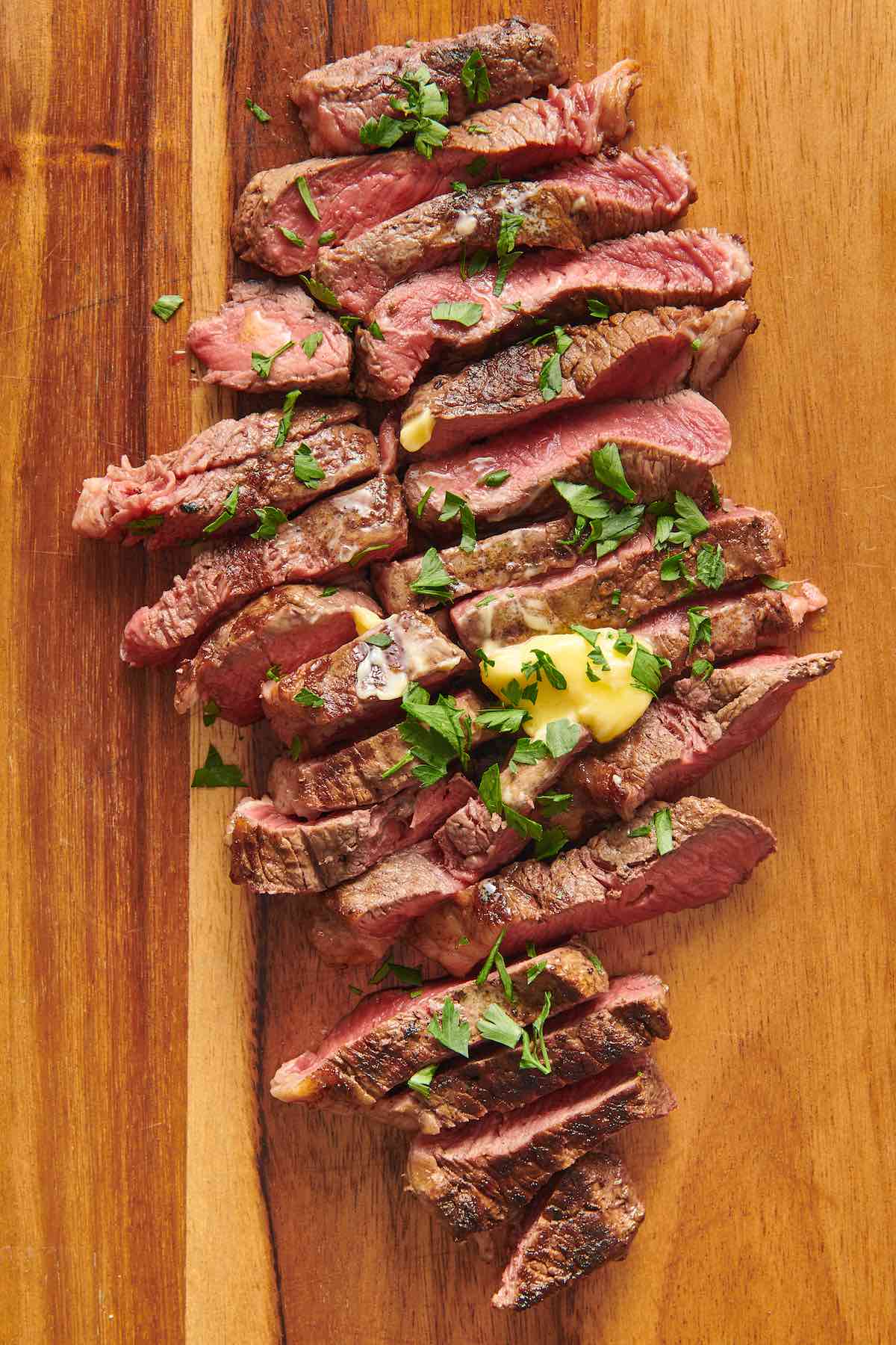 sliced coulotte steak with garlic butter.