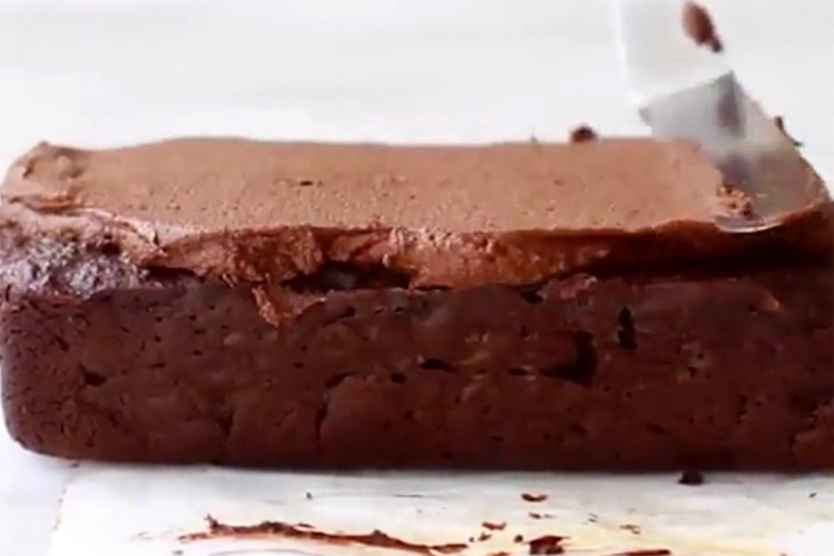 adding frosting to applesauce brownies.