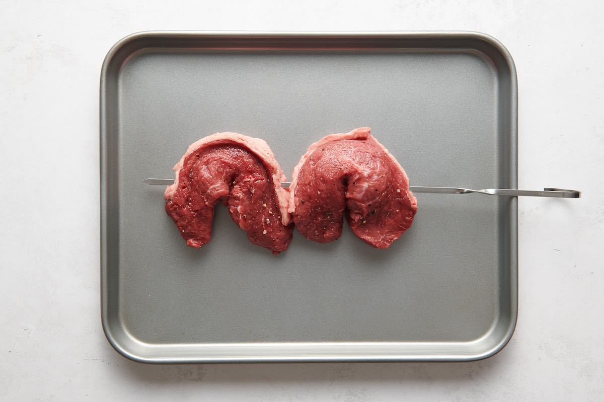 skewered raw steaks.