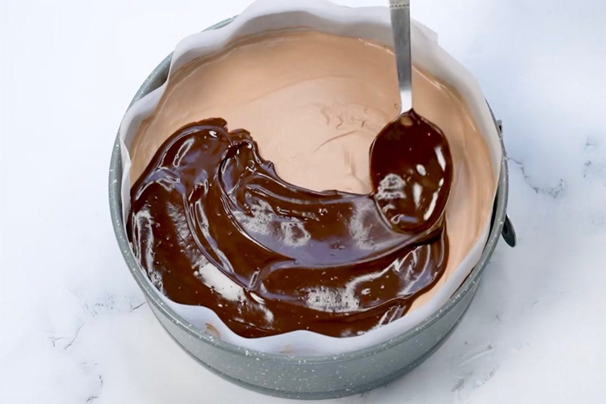 adding chocolate frosting to cheesecake mixture.