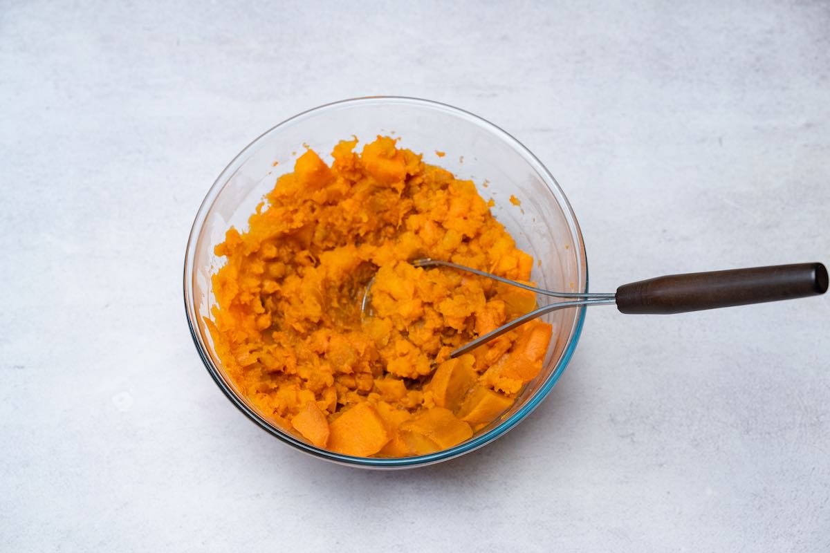 mashing sweet potatoes in bowl.