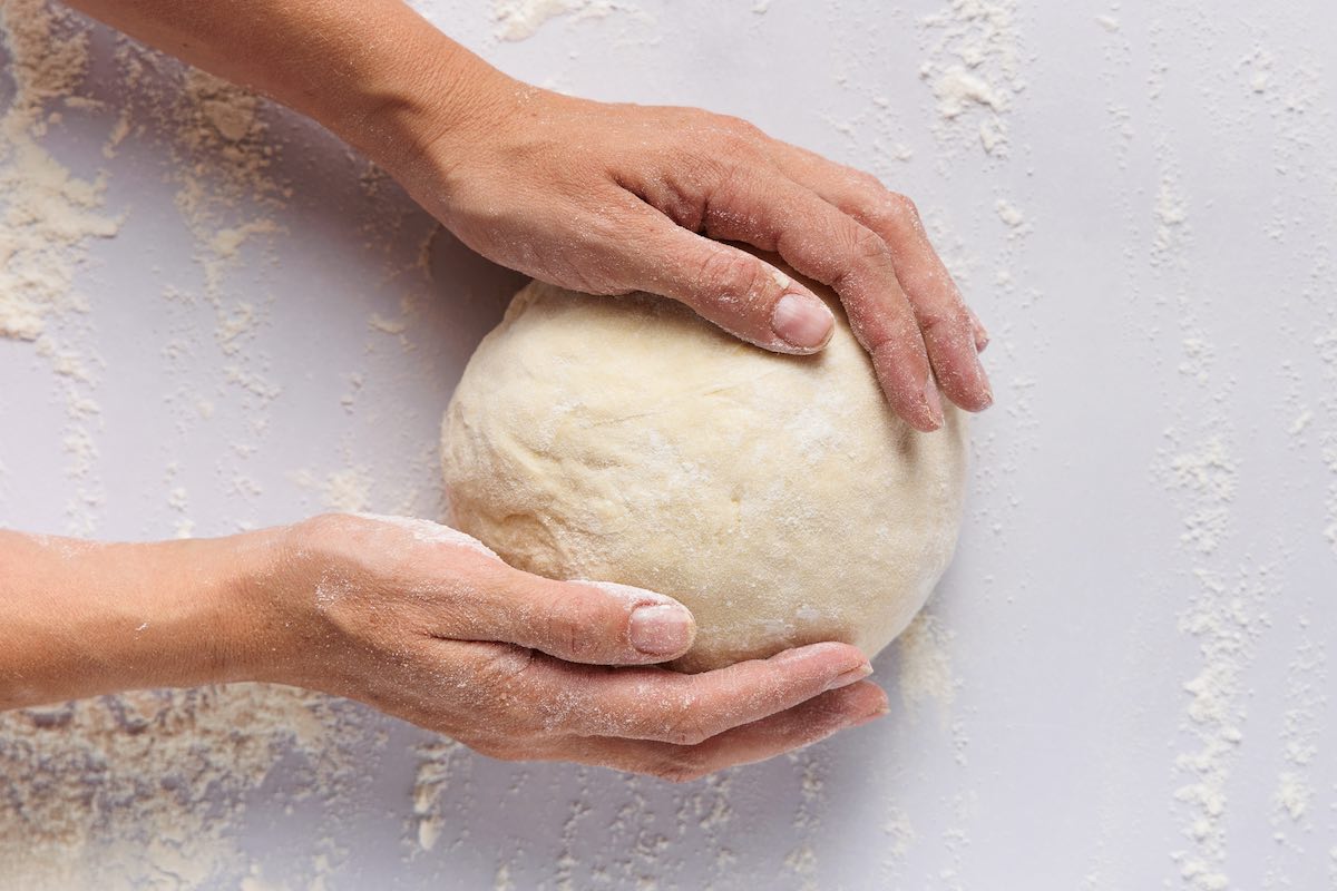 rolling out dough into a smooth ball.