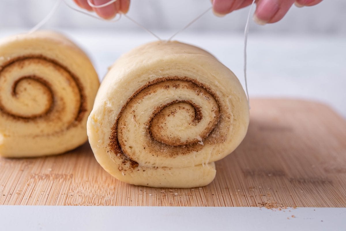 slicing vegan cinnamon rolls.