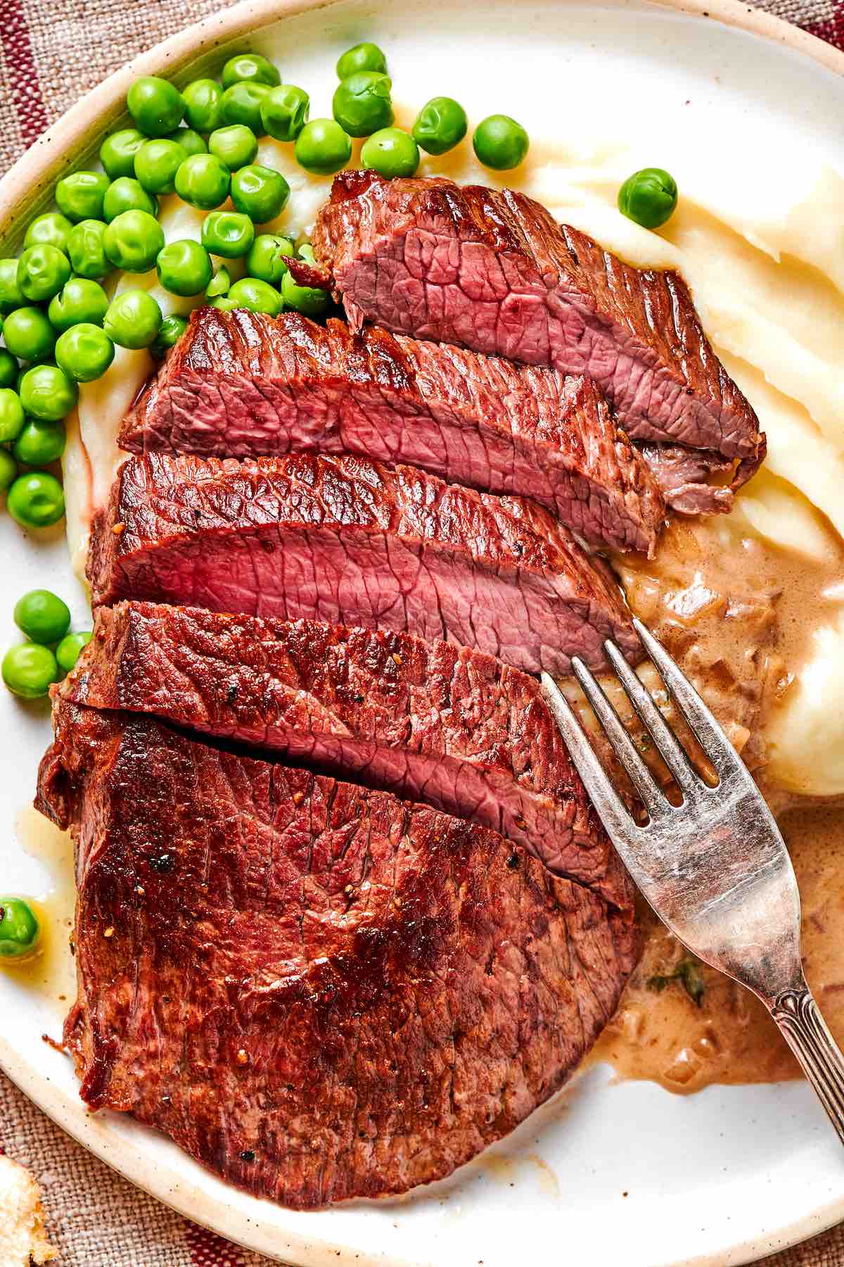sliced minute steaks with peas and mashed potatoes.