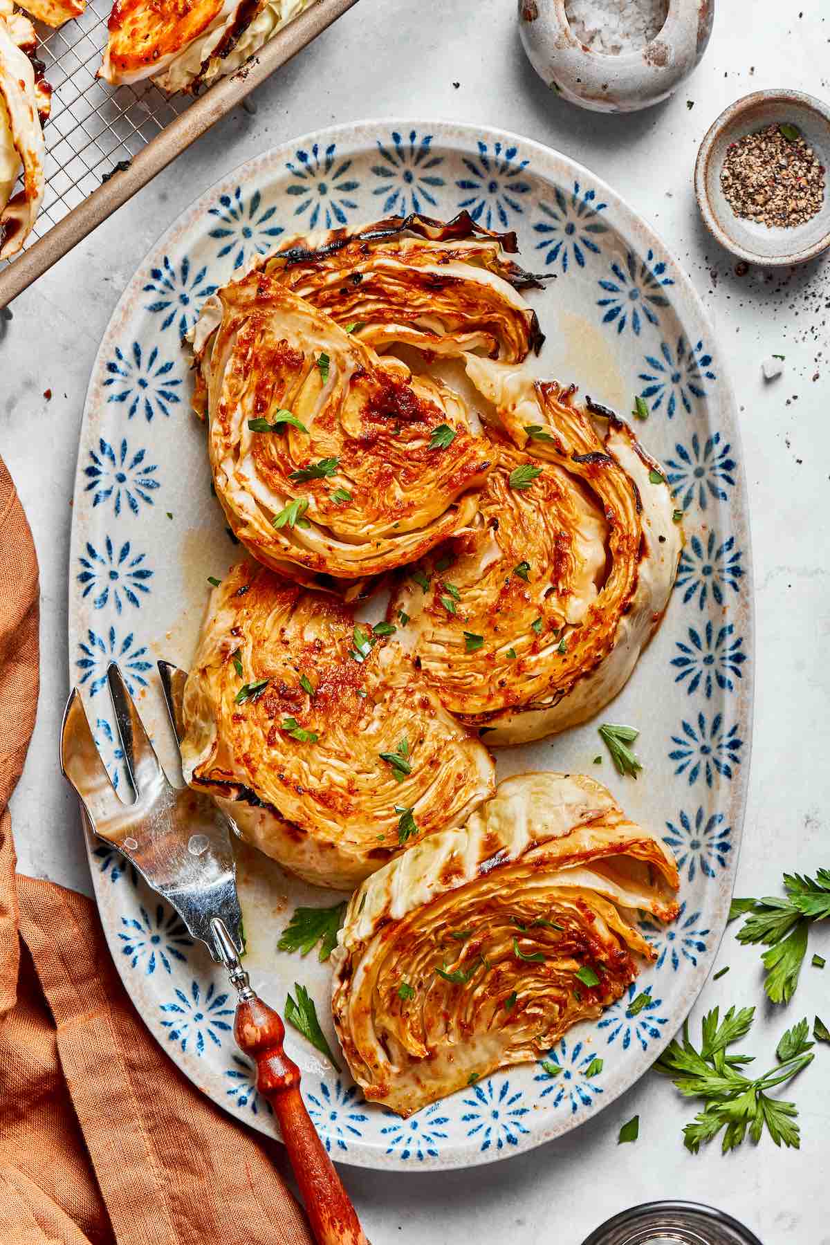air fryer cabbage on a white serving plate with chopped parsley on top.