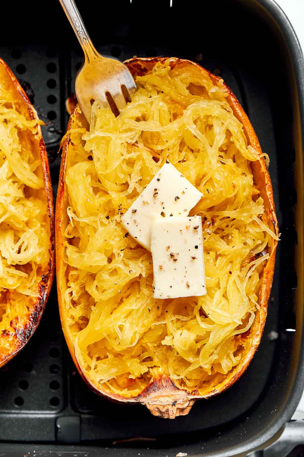 air fryer spaghetti squash with pat of butter on top.