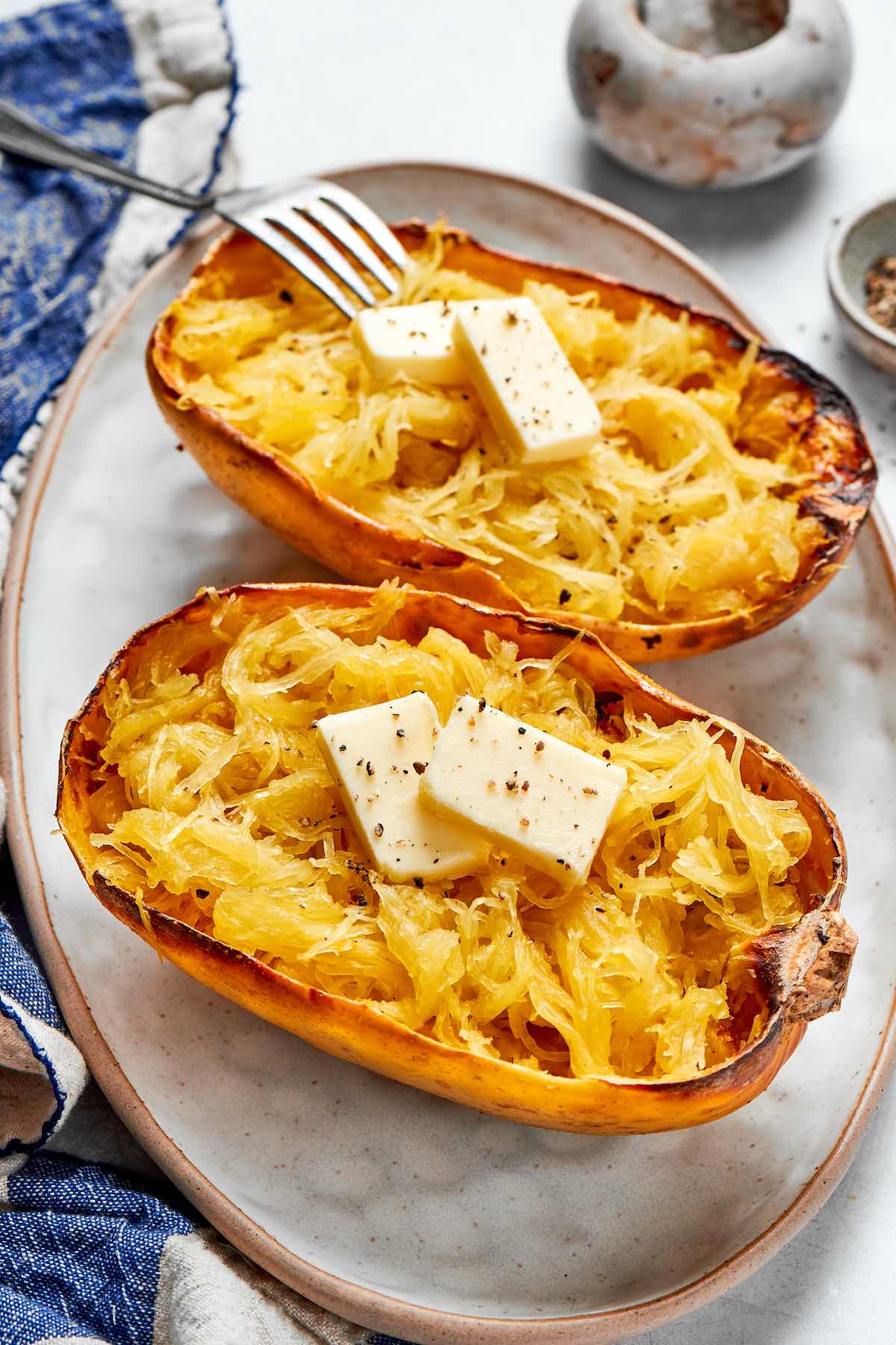 two air fried spaghetti squash boats with melted butter on top.