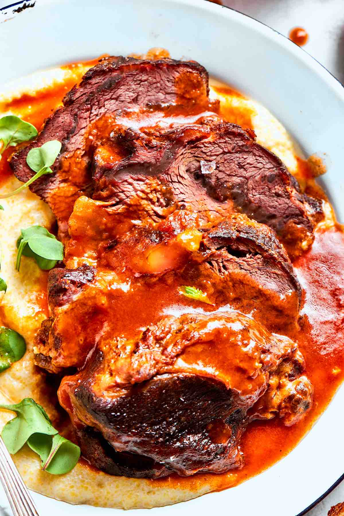 braised beef cheeks recipe over a bed of creamy mashed potatoes.