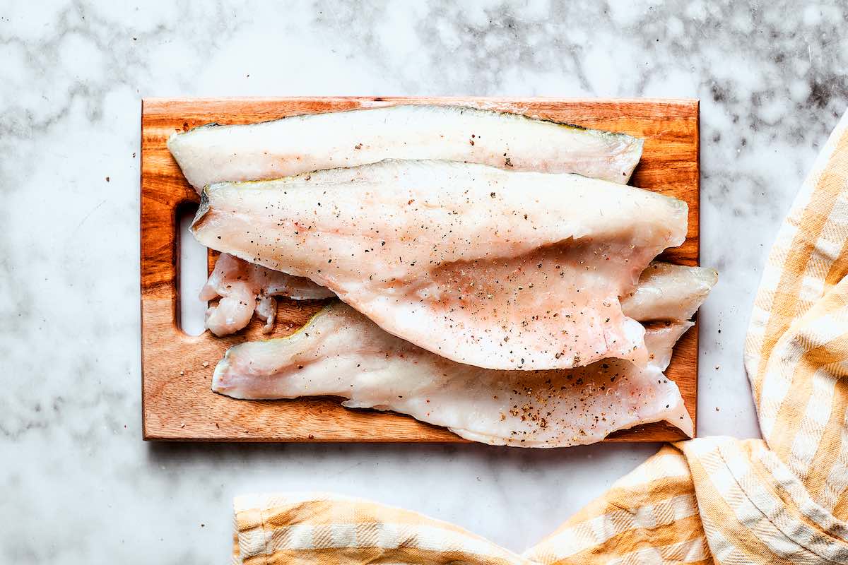 raw whiting fillets with salt and pepper.