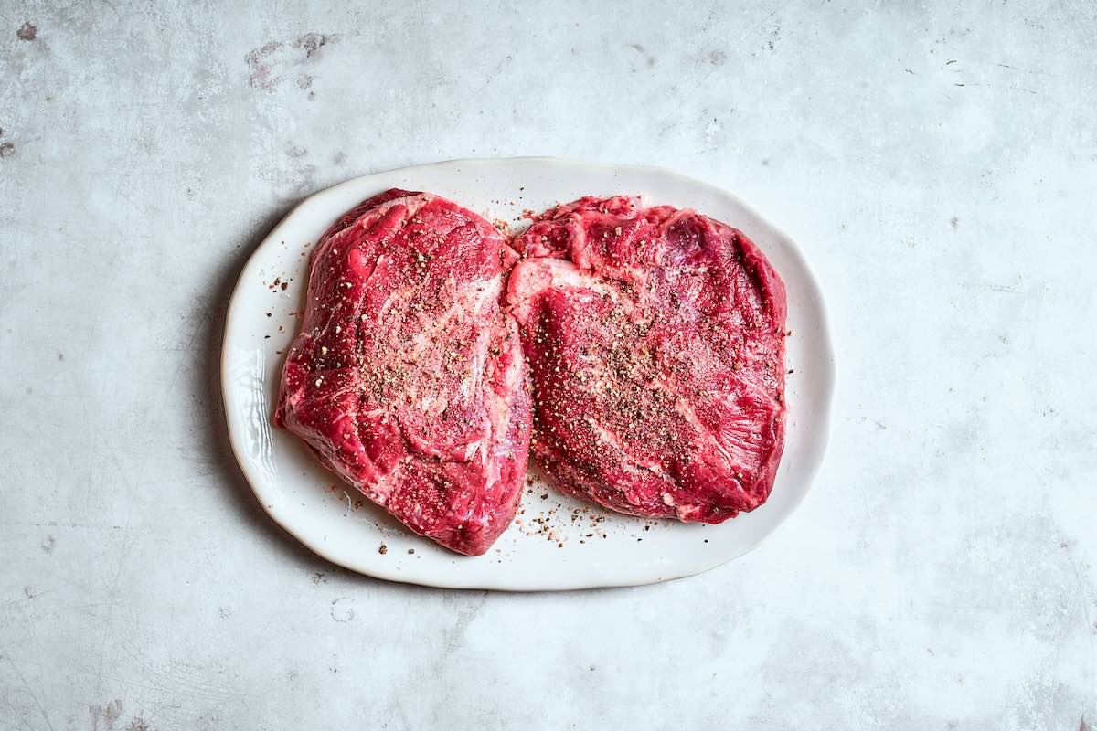 seasoned raw beef cheeks on a plate.