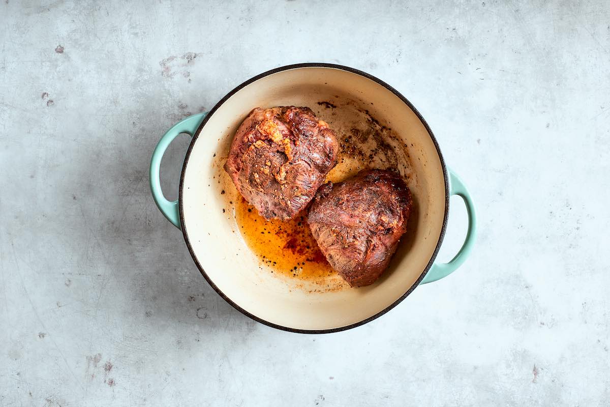 seared beef cheeks in Dutch oven.