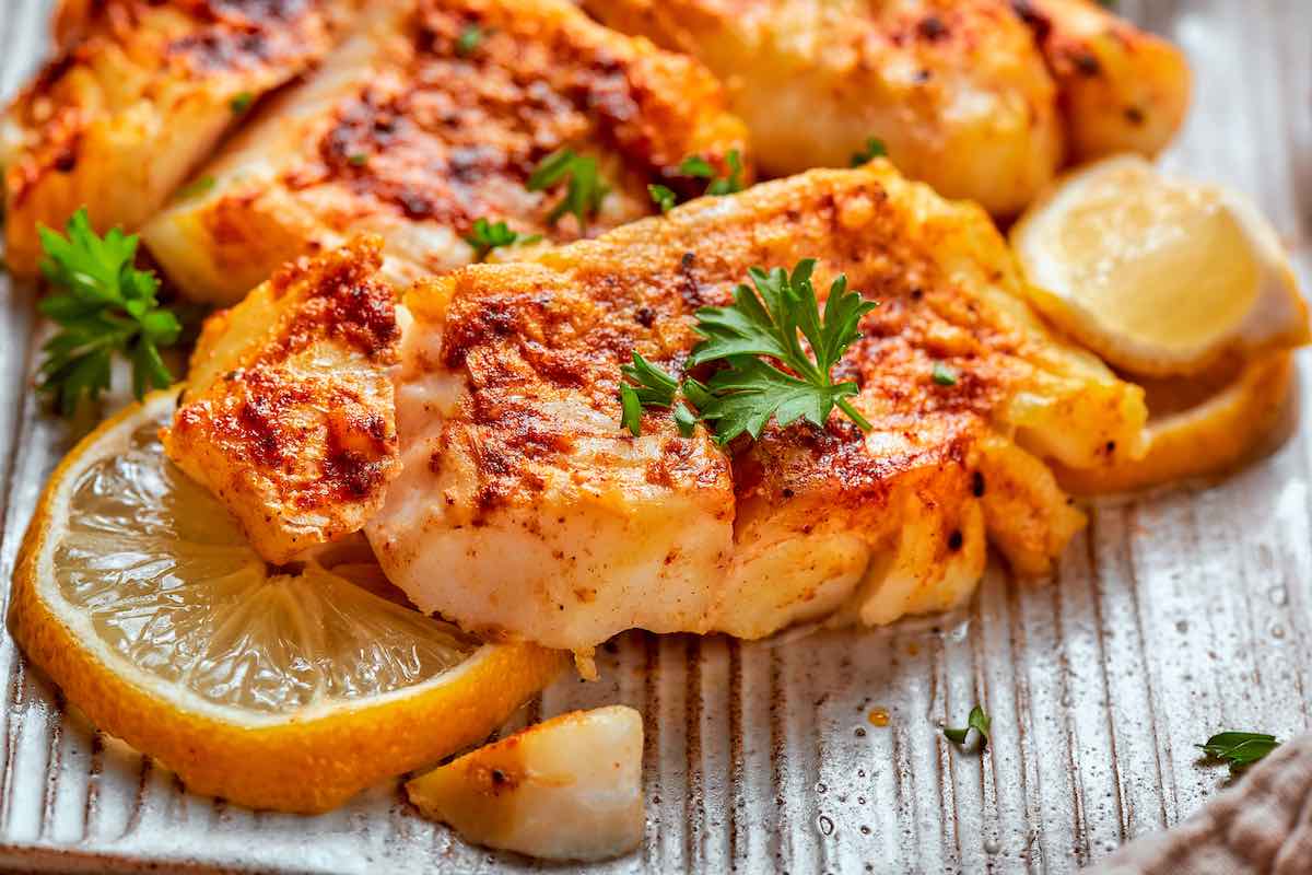 air fried halibut with fresh lemon wedges.