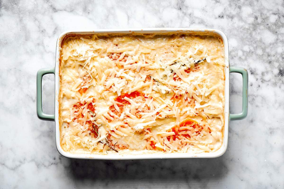 assembled squash casserole with shredded cheese on top.