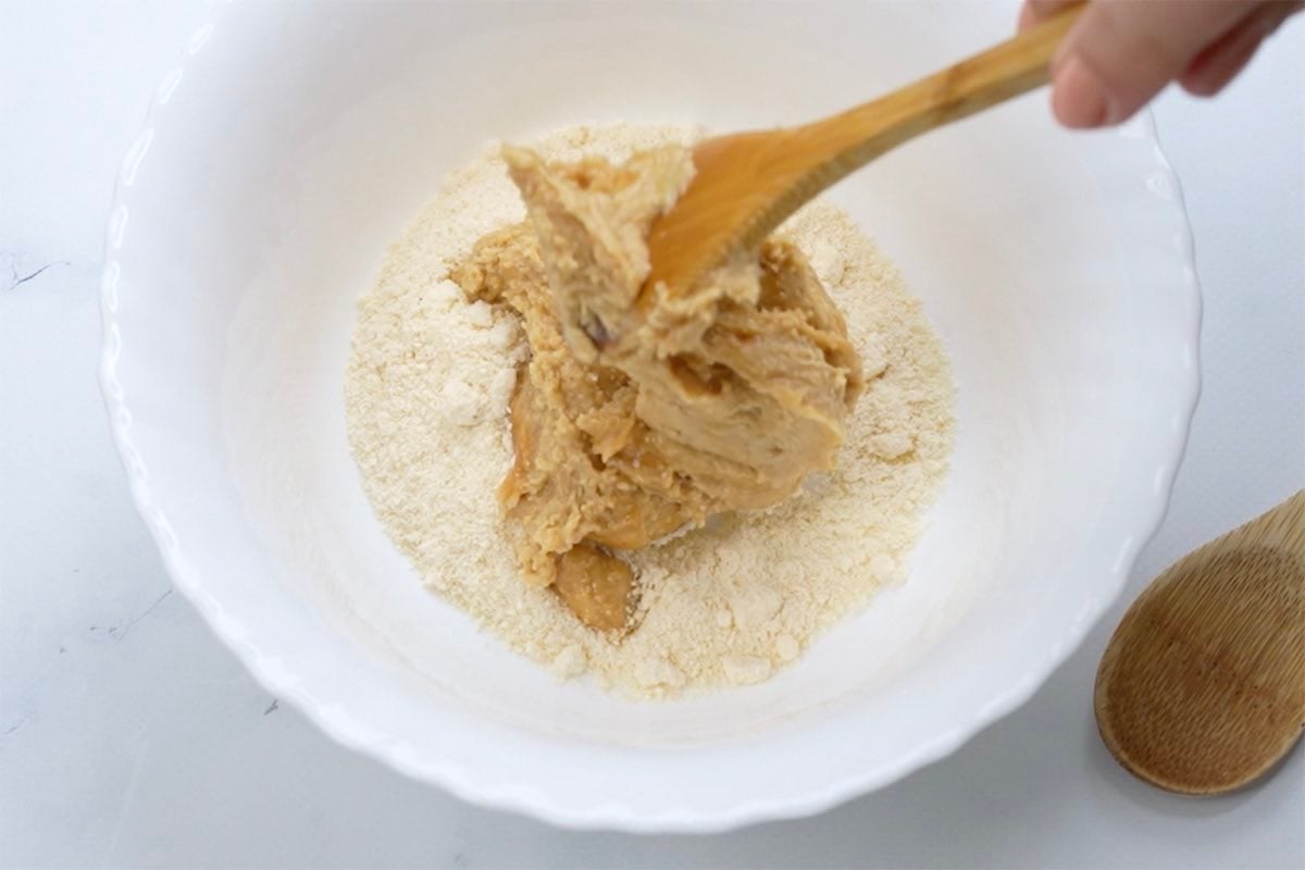 mixing peanut butter, maple syrup, and coconut flour together.