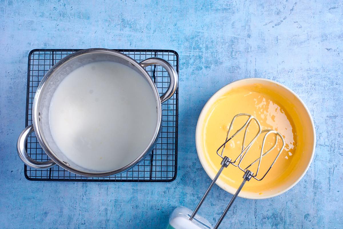 whisked egg yolks and allulose with a pot of warm cream.