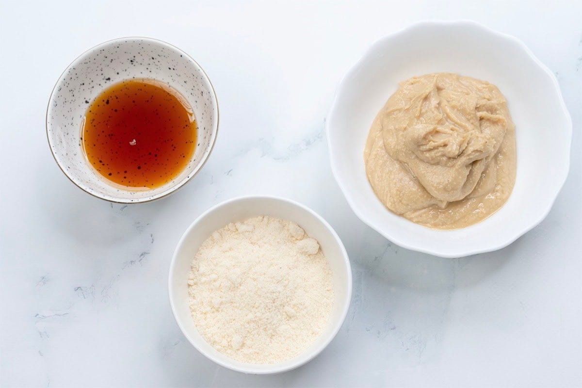 peanut butter, maple syrup, and coconut flour in three bowls.