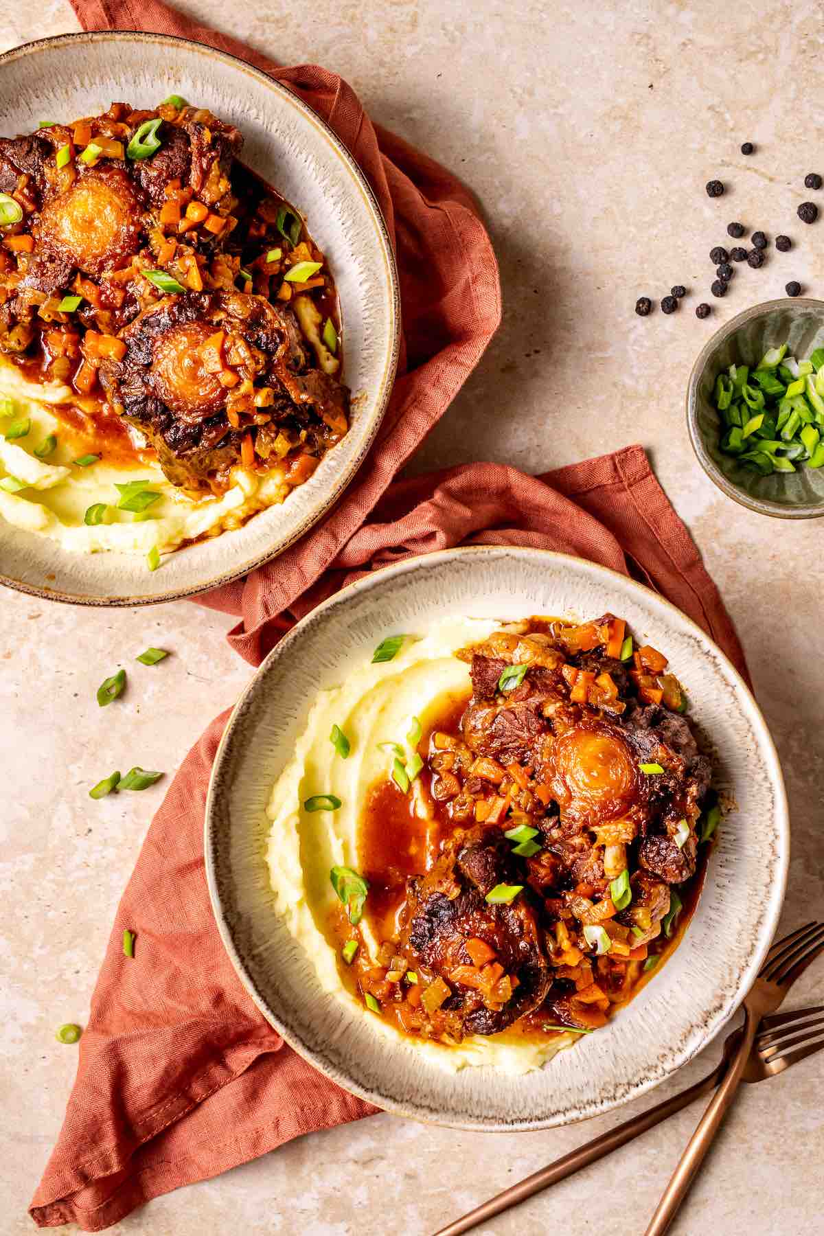 oxtail stew served over creamy mashed potatoes and fresh herbs.