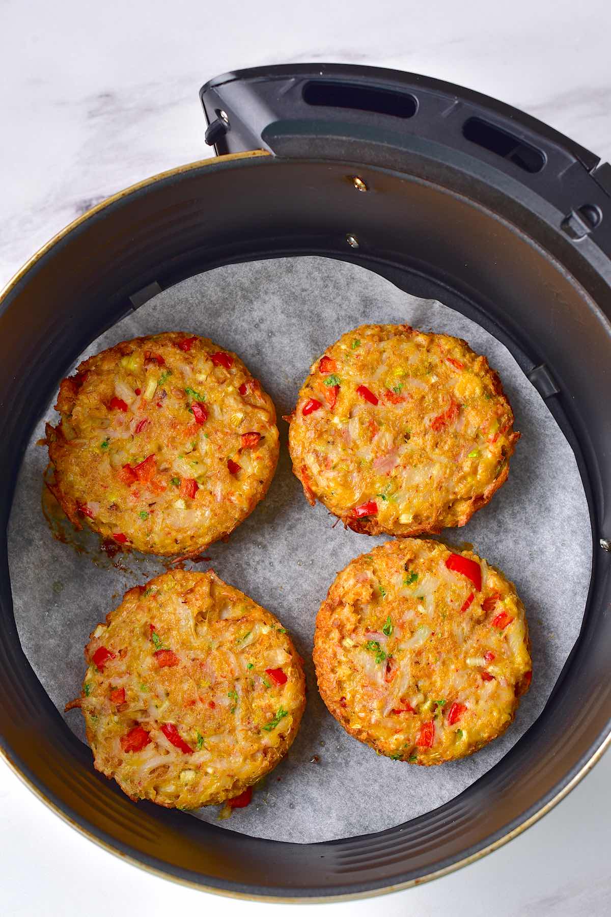 air fryer crab cakes in the air fryer basket.