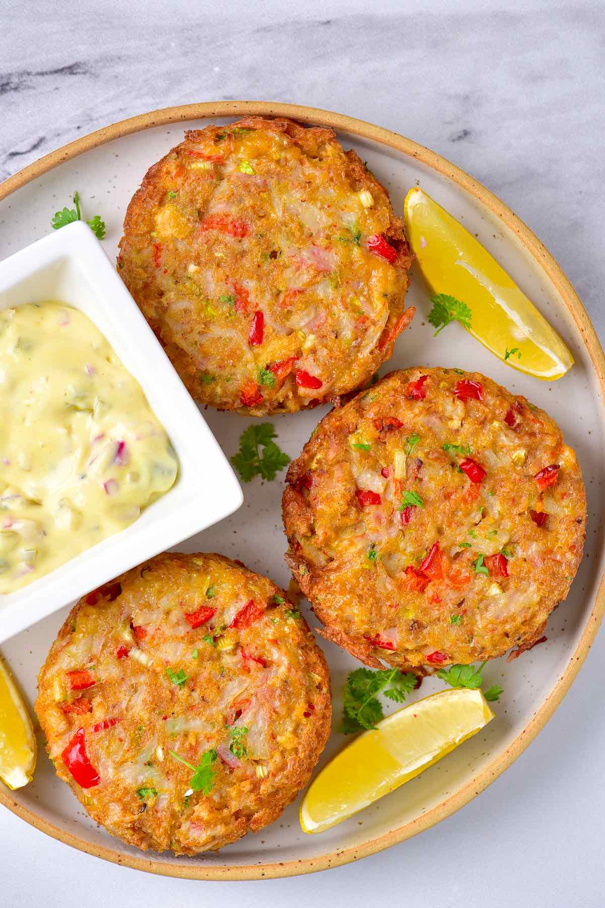 crispy crab cakes in air fryer with dipping sauce.