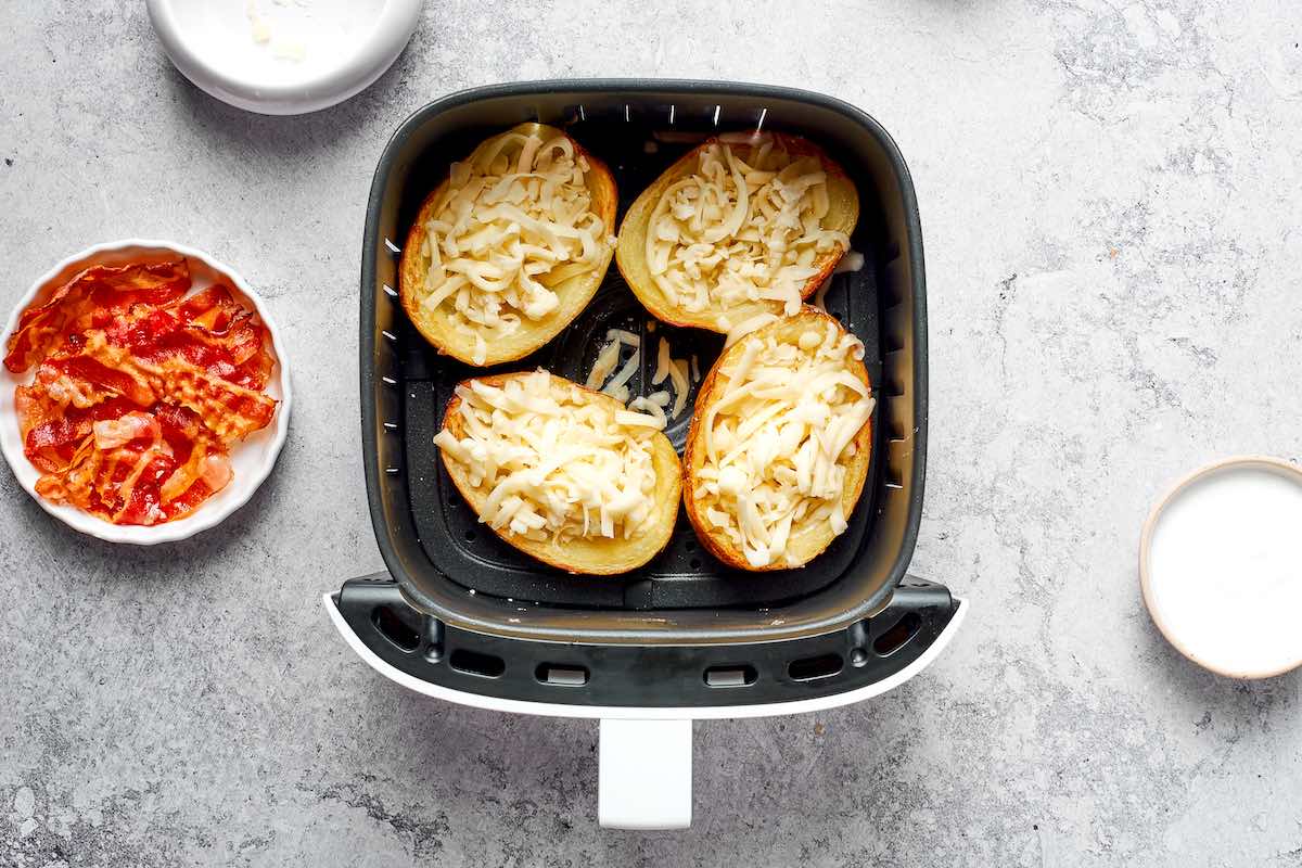 cheese filled potato skins in air fryer basket.