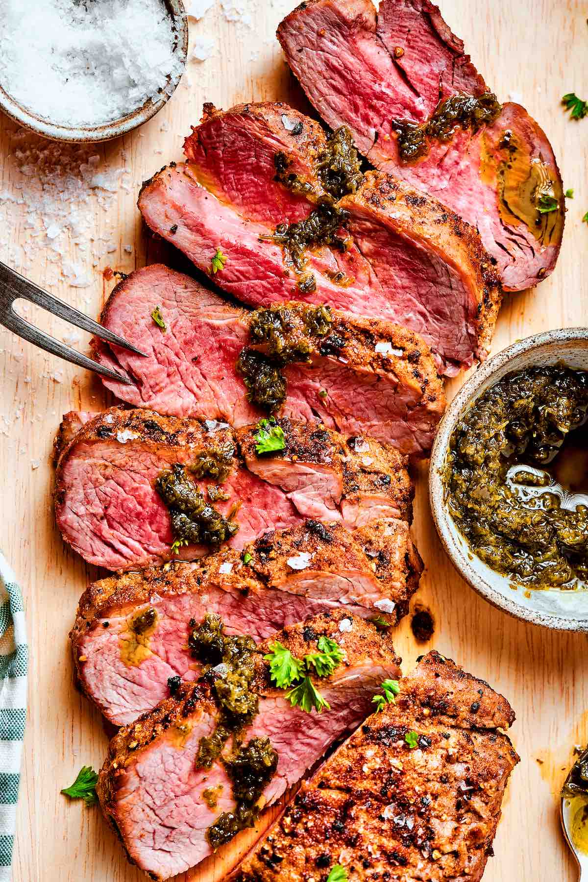 air fryer tri tip steak with chimichurri on top.