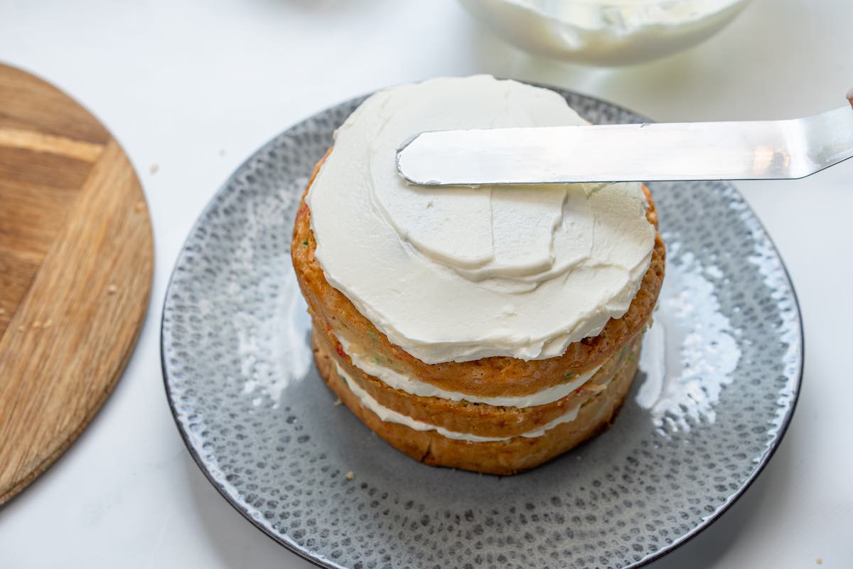 frosting the eggless funfetti cake.