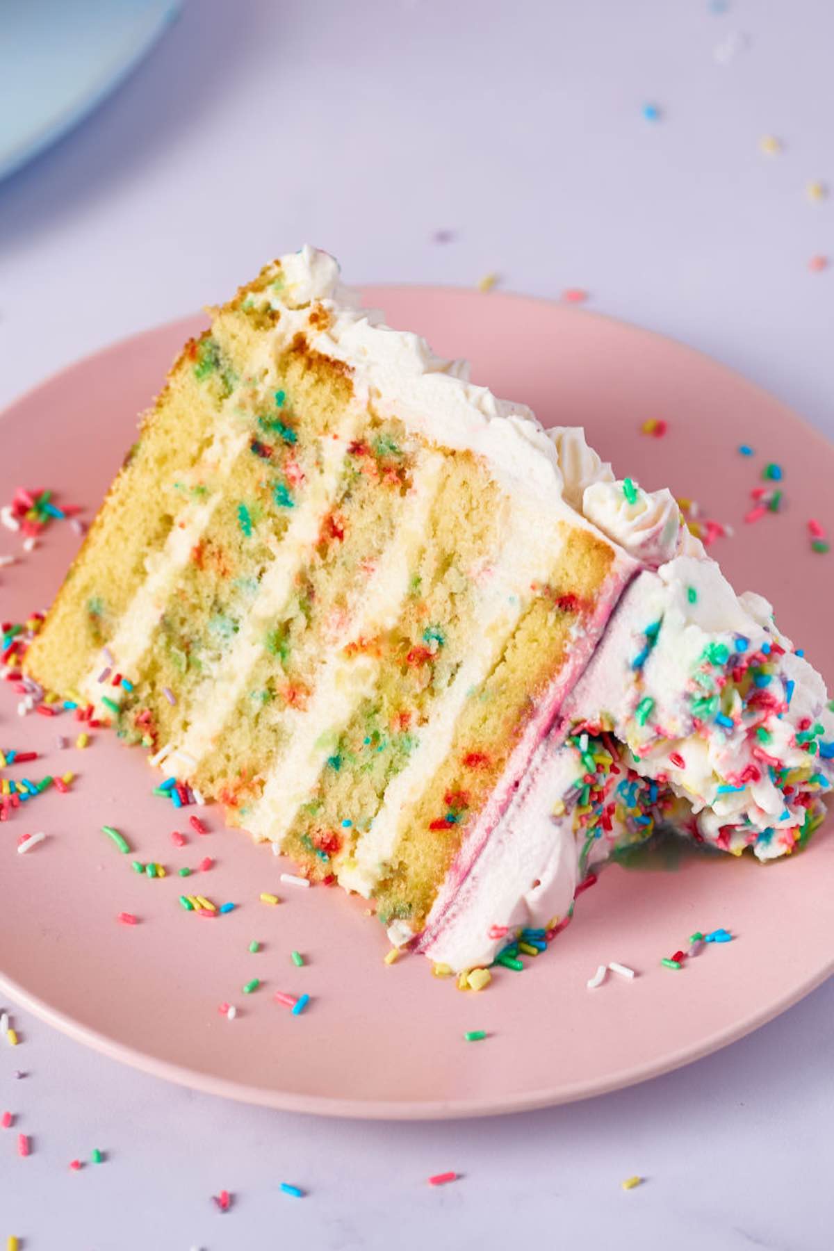 slice of eggless funfetti cake on a plate.