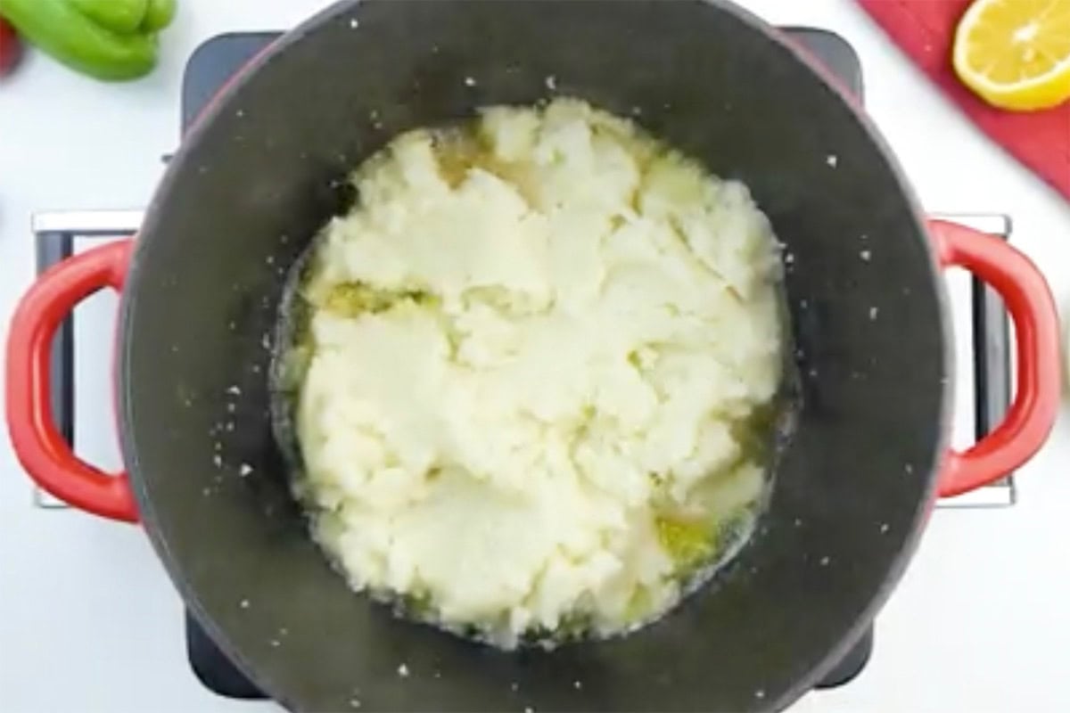 adding cauliflower to pot with buttery minced garlic mixture.