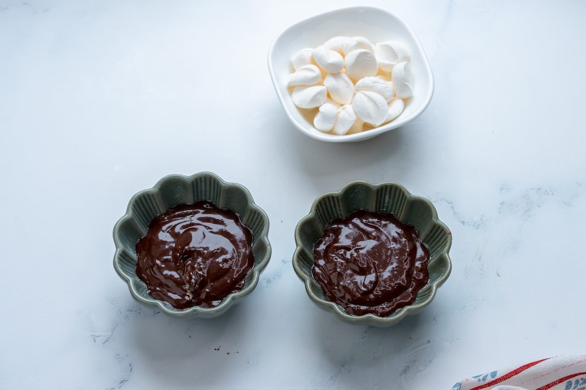 two mugs with cake batter in them.