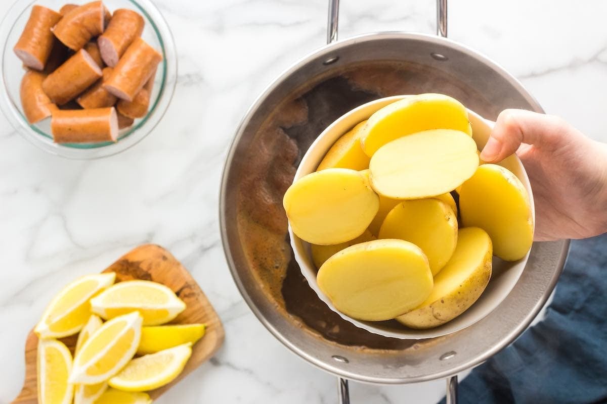 adding potatoes to seasoned boil.