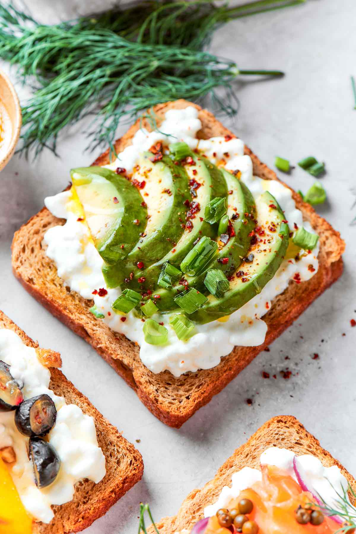 cottage cheese toast with sliced avocado, olive oil, and red pepper flakes.
