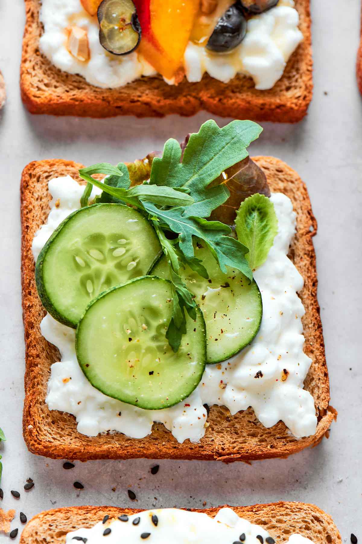 cottage cheese toast with sliced cucumbers, arugula, and flaky salt.