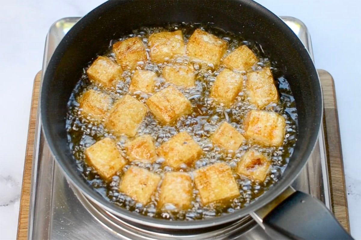 tofu frying in a deep pot.