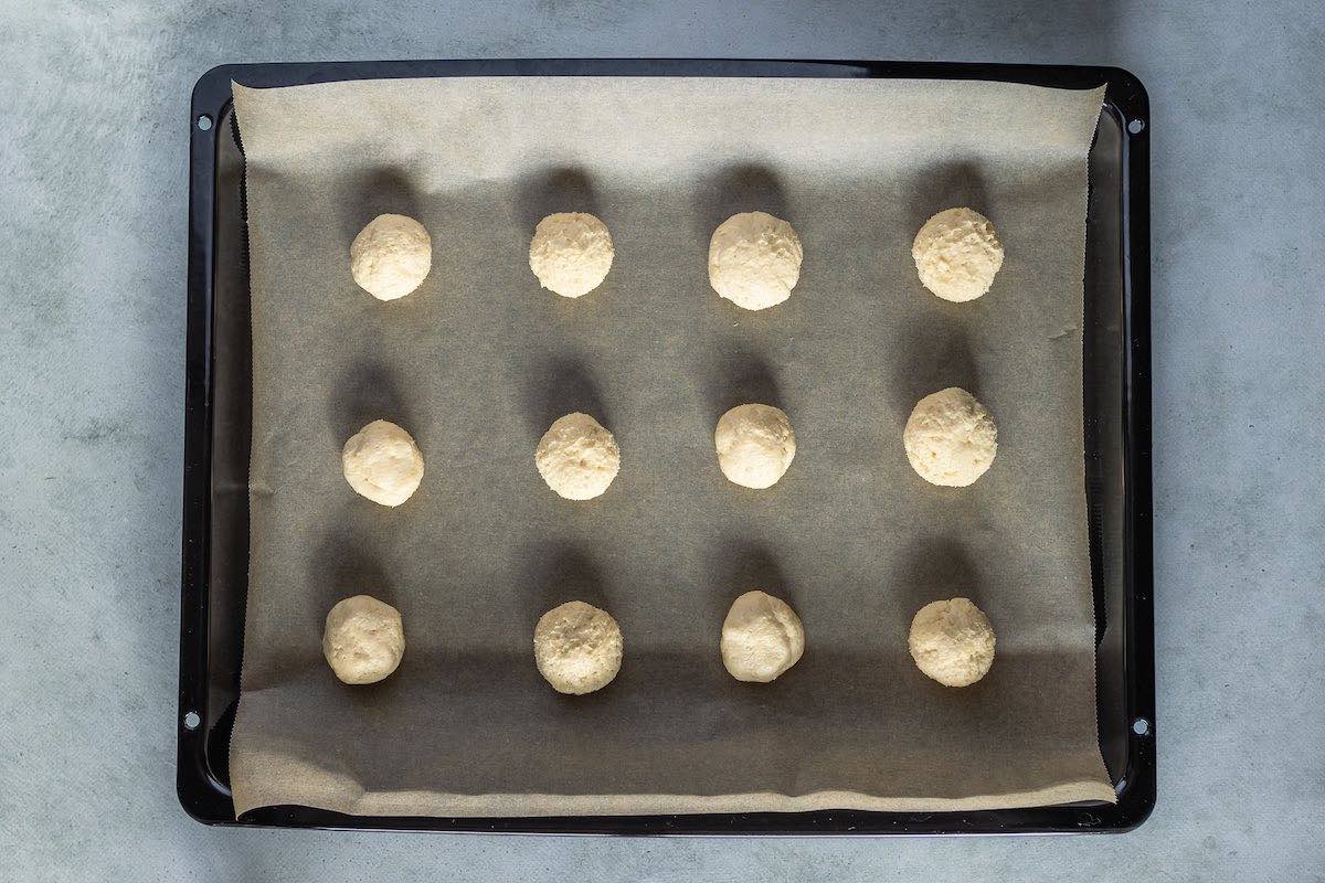 shaped balls of dough on a baking sheet.